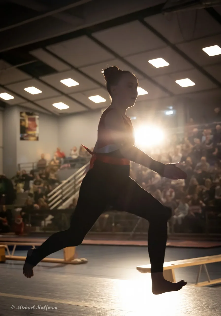 Gymnast i motljus på tävlingsgolvet