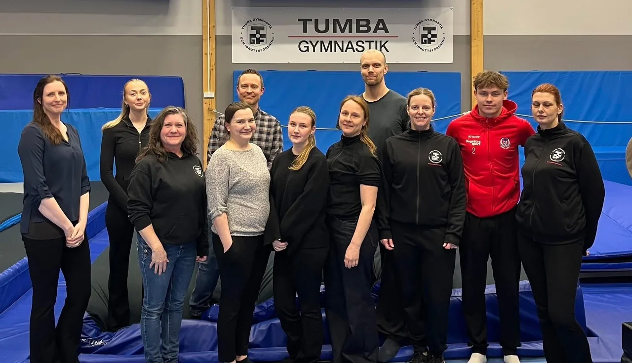 Gymnastiksektionens sektionsledning samlad i Trupphallen framför Tumba Gymnastik-banderollen